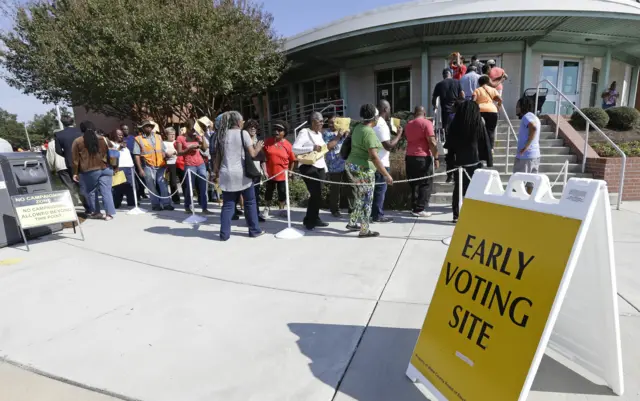 Voters line up on 20 October during early voting at Chavis Community Center in Raleigh, North Carolina.