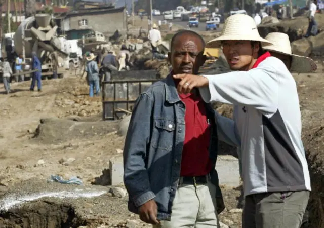 A Chinese construction worker (R) supervises the building of a road in Addis Ababa, 27 April 2007.