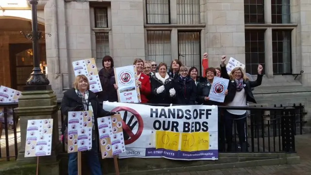 People with placards outside building