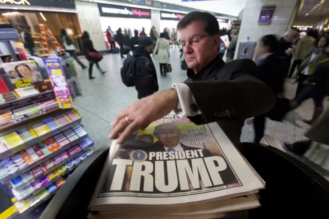 man reaches for the New York Post newspaper featuring president-elect Donald Trump"s victory, Wednesday, Nov. 9, 2016 in New York