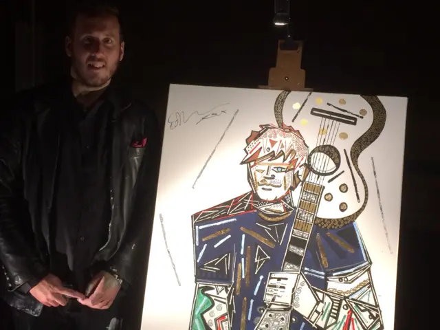 Ben Mosley standing by the portrait of Ed Sheeran, painted in abstract art form