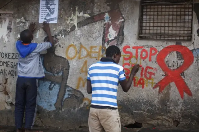 Man painting "stop stigma" on a wall in Kenya's capital, Nairobi - 1 December 2016