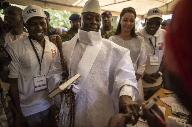 Incumbent Gambian president Yahya Jammeh (C) has his finger inked before casting his marble in a polling station in a presidential poll, in Banjul on 1 December 2016