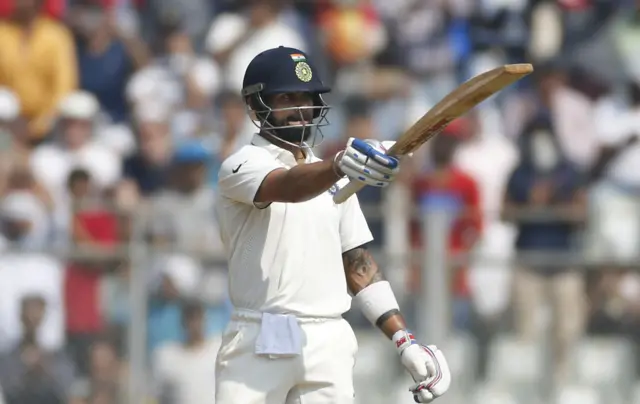 Virat Kohli raises his bat