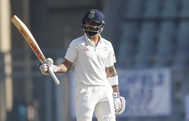 Virat Kohli raises his bat