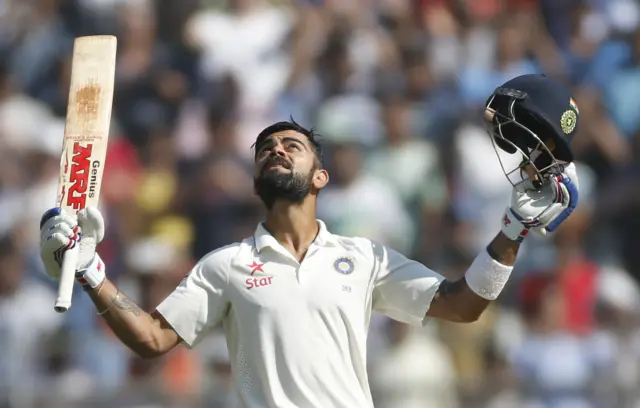 Virat Kohli raises his bat