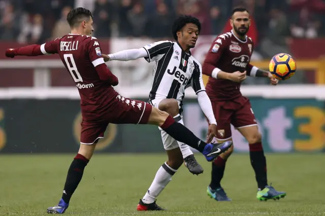 Daniele Baselli of Torino challenges Juventus' Juan Cuadrado