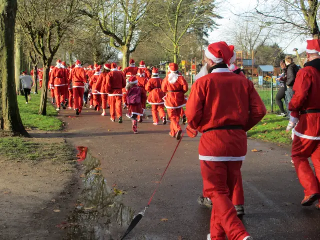 Santa Claus's running and walking around Eaton Park