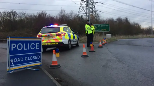 Road closed sign and police car