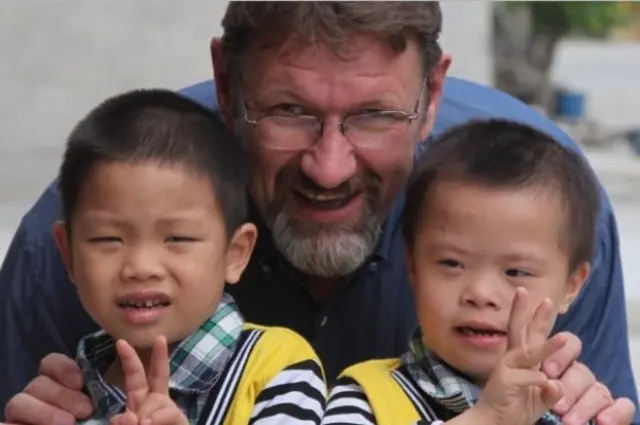 Robert Glover, with two Vietnamese children