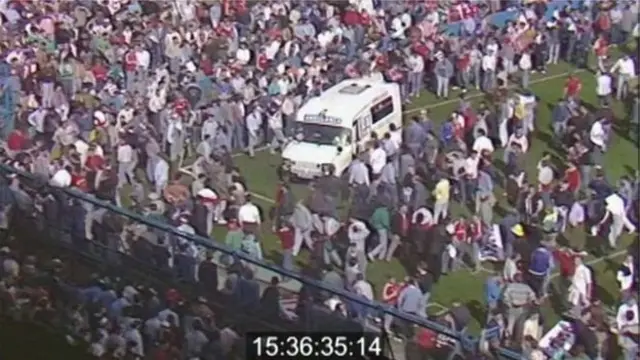 Crowd and ambulance on the pitch