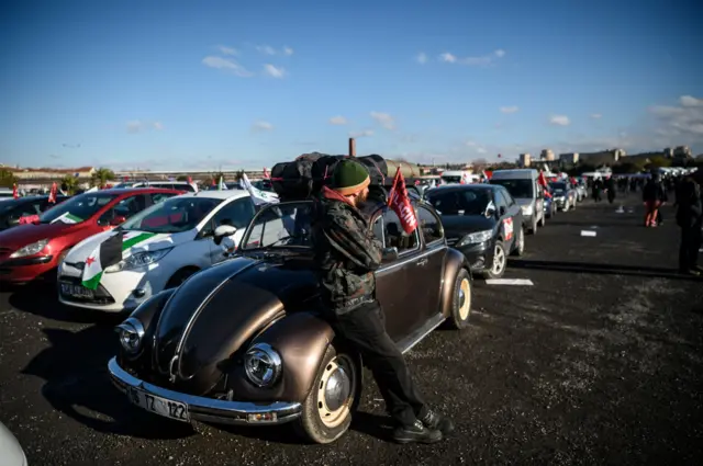 People wait with their cars to join an aid convoy to Aleppo organized by IHH Humanitarian Relief Foundation about to leave, on December 14, 2016 in Istanbul. Turkey"s aid campaign for the besieged people of Aleppo continued with several nongovernmental organizations sending food, water and clothing.