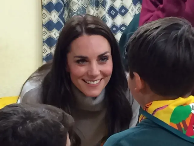 The Duchess of Cambridge crouches down to a young Cub