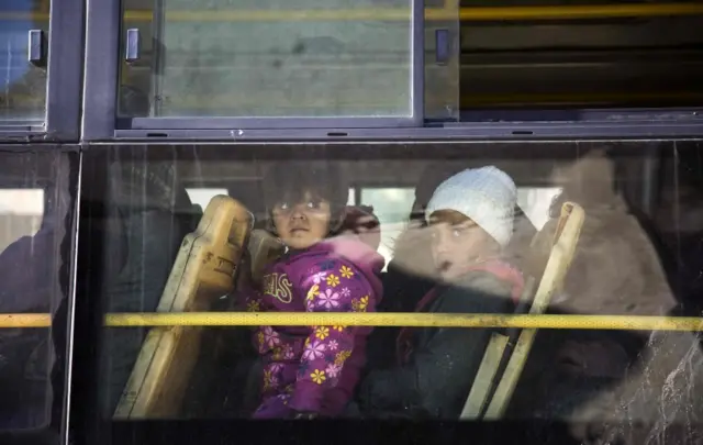 Children awaiting evacuation from rebel-held Aleppo sit on bus (15 December 2016)