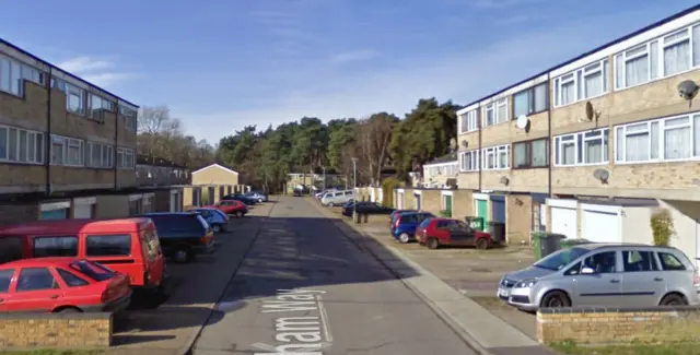 A view of Durham Way, showing maisonettes, cars and garages