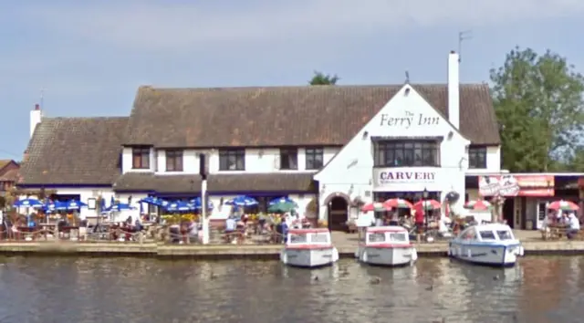 The Ferry Inn at Horning, seen from across the river, with boats moored outside