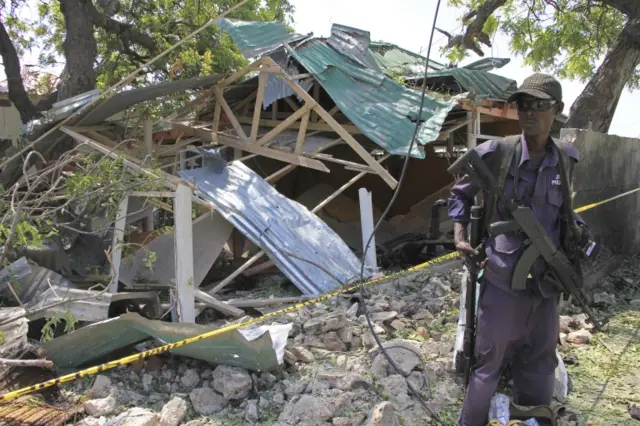 Somalia soldier stands guard near the destroyed restauran