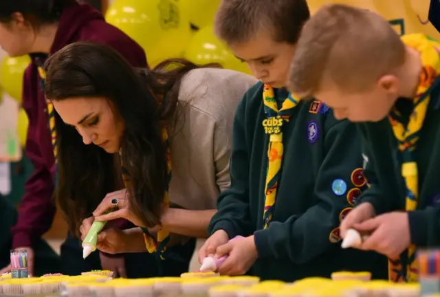 The Duchess of Cambridge icing cupcakes, with Cub Scouts