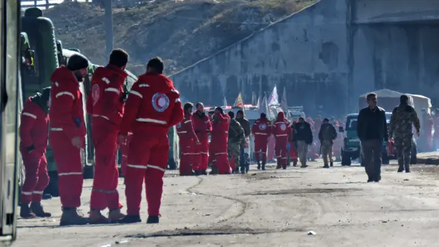 Syrian Red Crescent workers waiting by buses