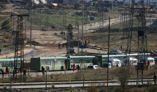 Buses and ambulances wait to evacuate civilians and rebels from eastern Aleppo, Syria