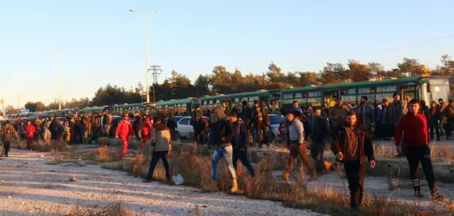 Evacuees from rebel-held east Aleppo disembark from buses upon their arrival in the rebel-held town of al-Rashideen