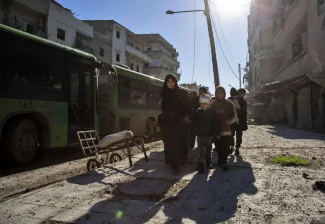 Syrians gather during an evacuation operation of rebel fighters and their families from rebel-held neighbourhoods on December 15, 2016 in the embattled city of Aleppo.