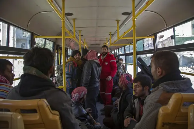 Men sit on a bus ahead of their evacuation from rebel-held Aleppo (15 December 2016)