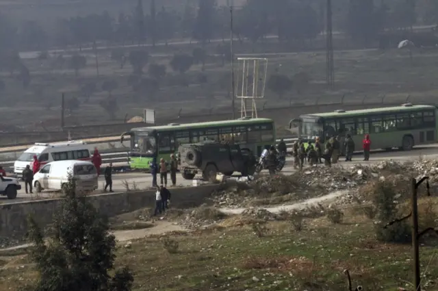 Syrian official news agency SANA, green government buses carry residents evacuating from eastern Aleppo, Syria, Friday, Dec. 16, 2016.