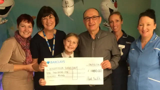 April (centre) and her mum (far left) presented the cheque to hospital staff