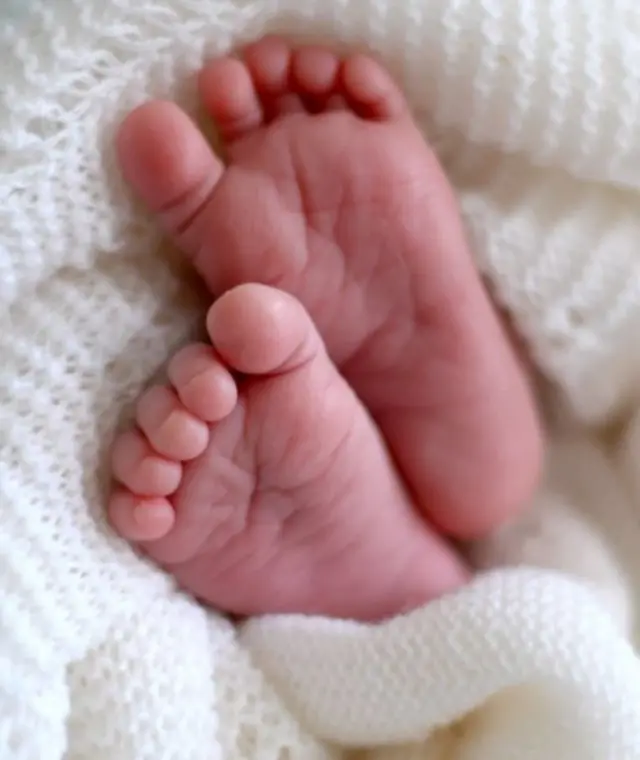 New born baby's feet in a white blanket