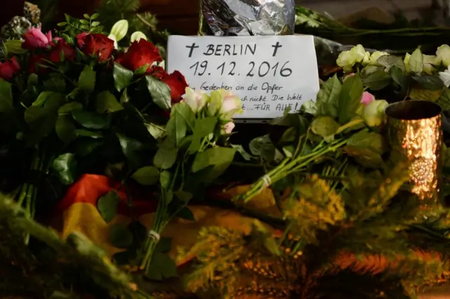 A note is placed among bunch of flowers to pay tribute to the victims at the site of the lorry attack in Berlin