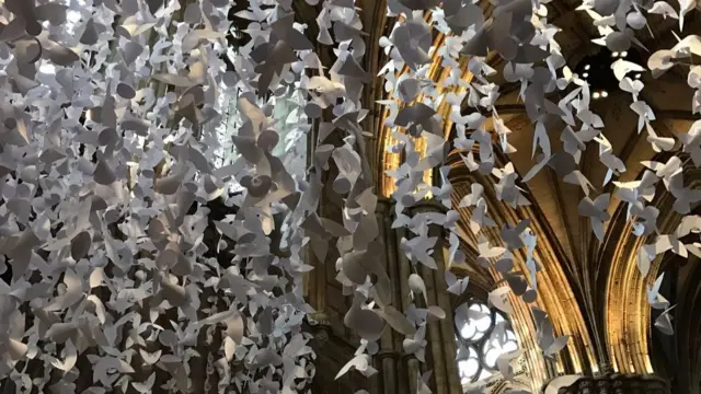 Paper angels suspended from ceiling