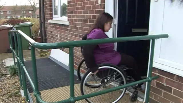 Woman in wheelchair using ramp