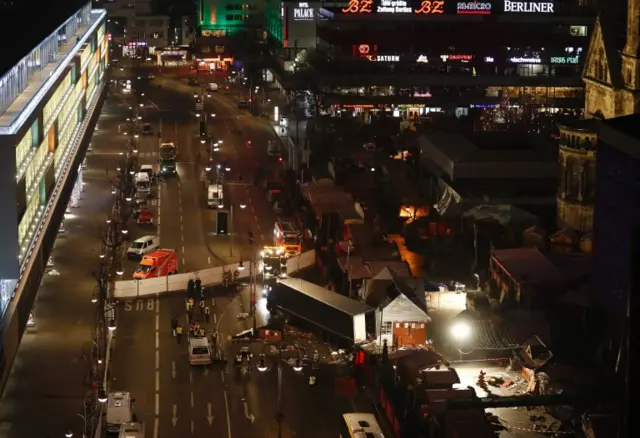 Forensic experts examine the scene around a truck that crashed into a Christmas market on 20 December