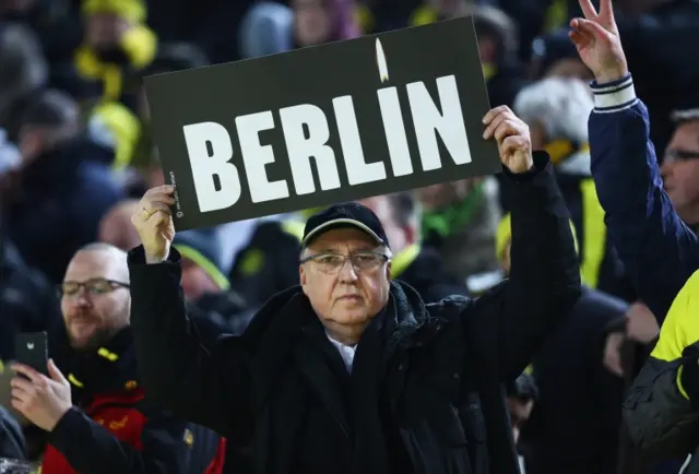 A fan holds a sign as he remembers the victims of the Berlin attack before the Bundesliga match between Borussia Dortmund and FC Augsburg at Signal Iduna Park