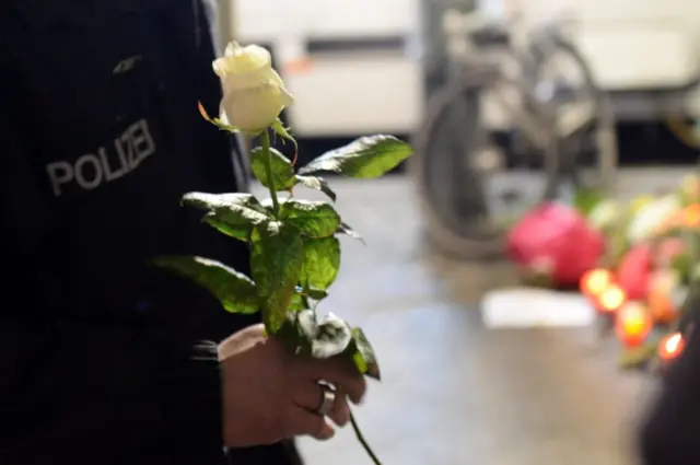 A policeman holds a rose in tribute to the victims of the truck attack in Berlin