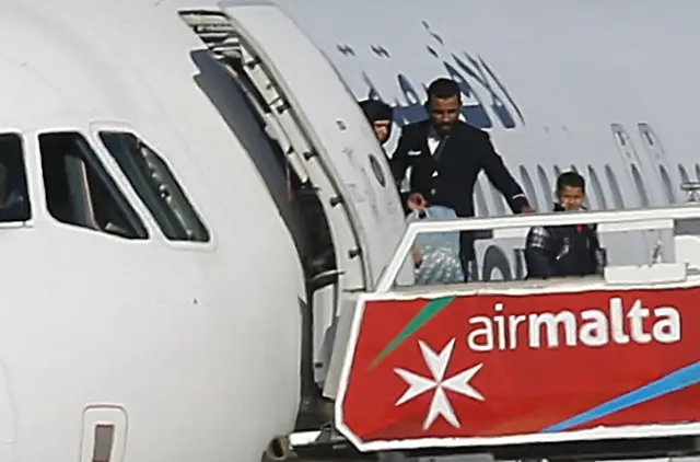 People disembark from a hijacked Libyan Afriqiyah Airways Airbus A320 on the runway at Malta Airport, December 23, 2016