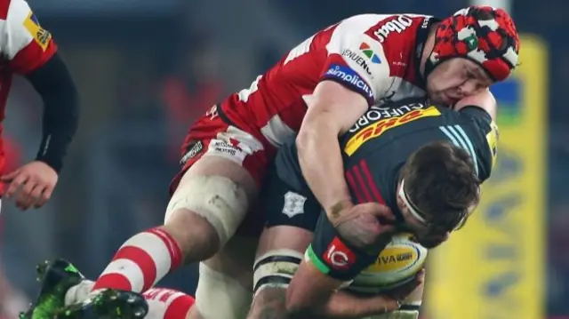 Jack Clifford of Harlequins is tackled by Tom Savage of Gloucester