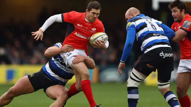 Alex Goode of Saracens is tackled by Max Lahiff of Bath