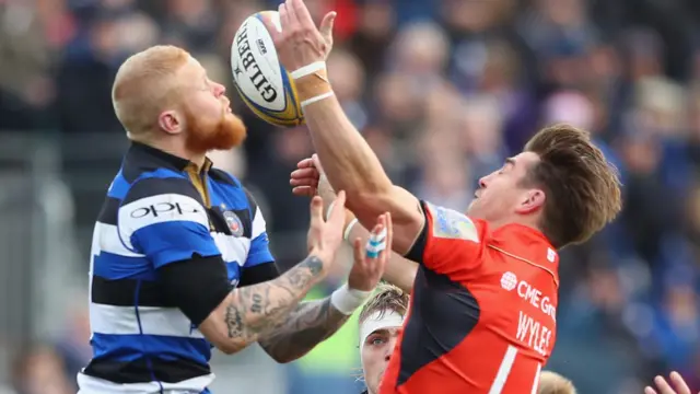 Tom Homer of Bath challenges Chris Wyles of Saracens for a high ball