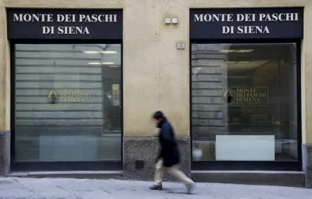 A man walks in front of the Monte dei Paschi bank in Siena, Italy