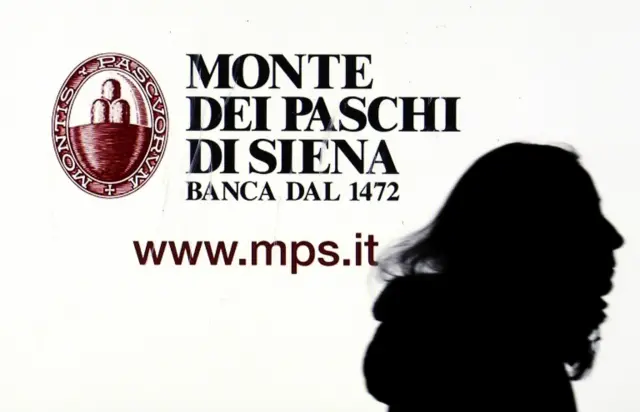 A Monte dei Paschi di Siena advertisement is seen on a screen in a bank window in downtown Milan