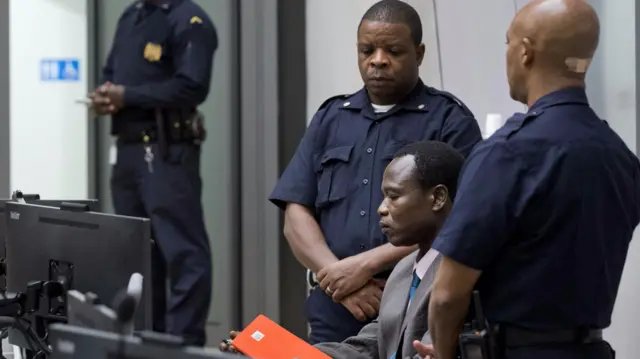 Dominic Ongwen being guarded at court in The Hague