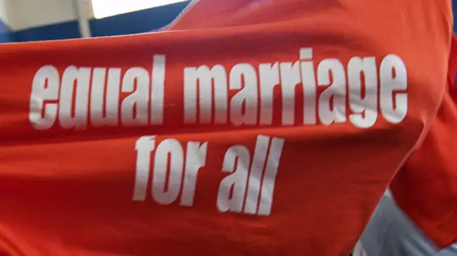 A lesbian holding up an equal marriage for all T-shirt in South Africa