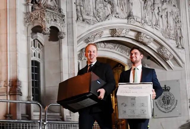 Officials carrying documents into the Supreme Court