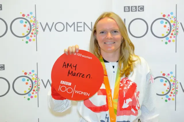 Susie Rodgers, holding a sign with the name Amy Marren on it