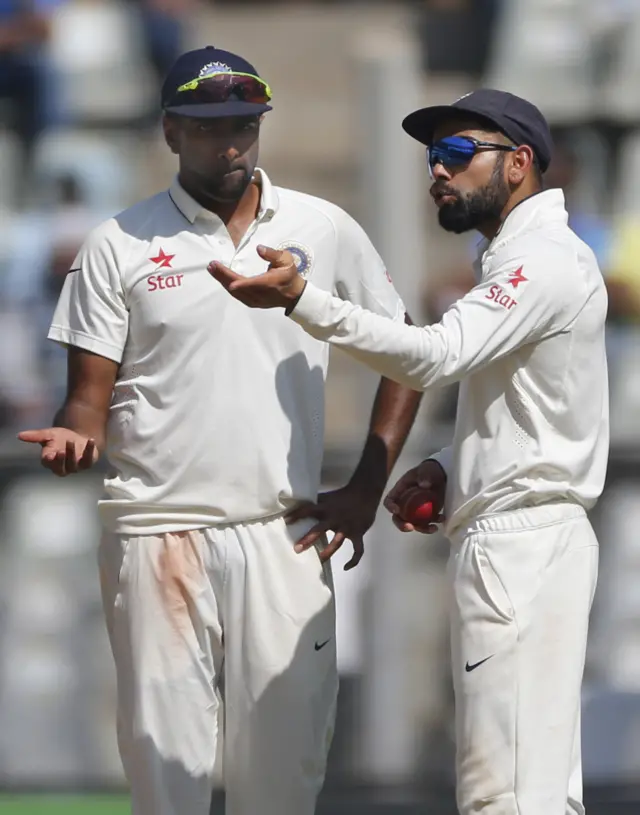 India captain Virat Kohli speaks with teammate Ravichandran Ashwin