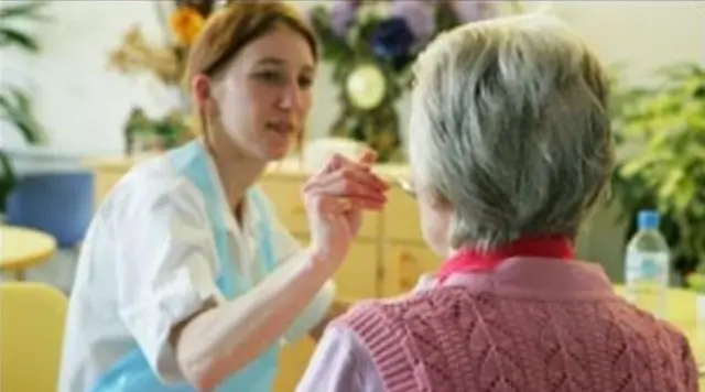 Nurse feeding an older woman