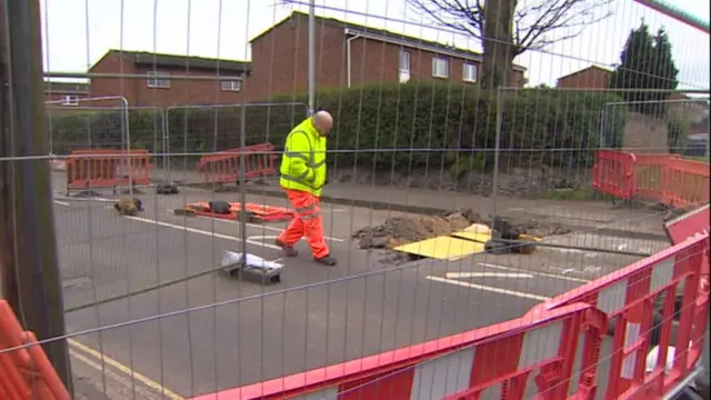 The hole on Plumstead Road, with engineer looking at it