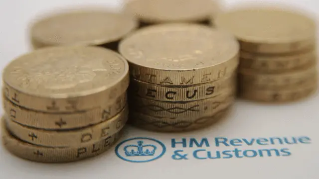 £1 coins sitting beside HM Revenue and Customs logo